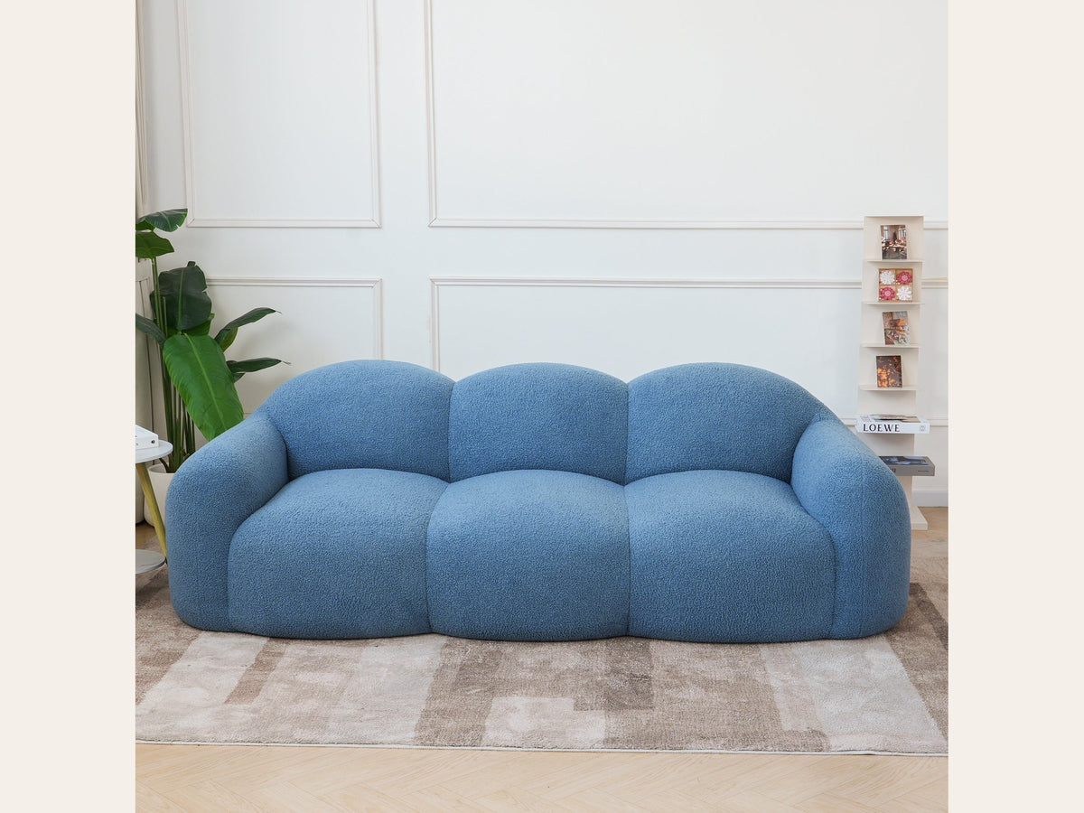 Canapé nuage 3 places avec accoudoirs, tissu bouclé bleu azur, en situation dans un intérieur