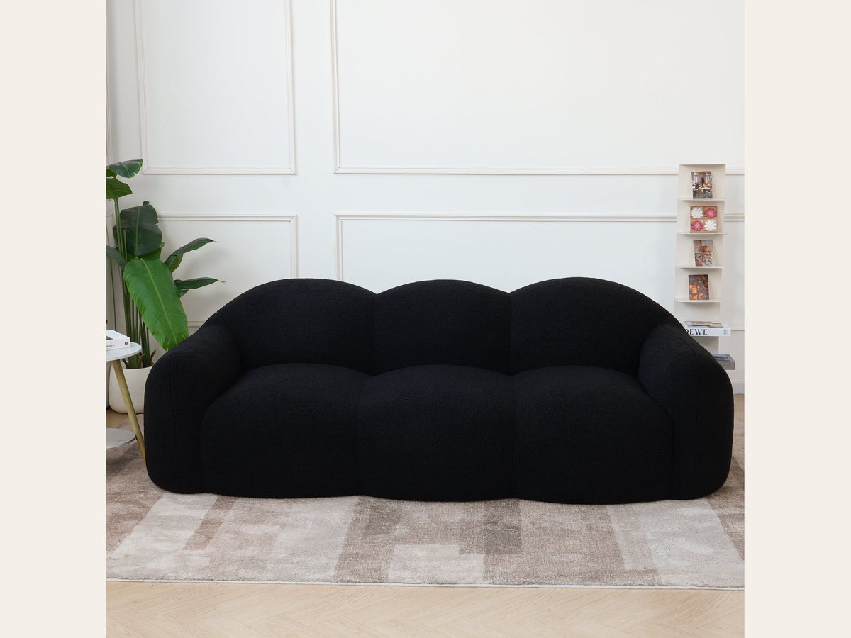 Canapé nuage 3 places avec accoudoirs, tissu bouclé noir charbon, en situation dans un intérieur