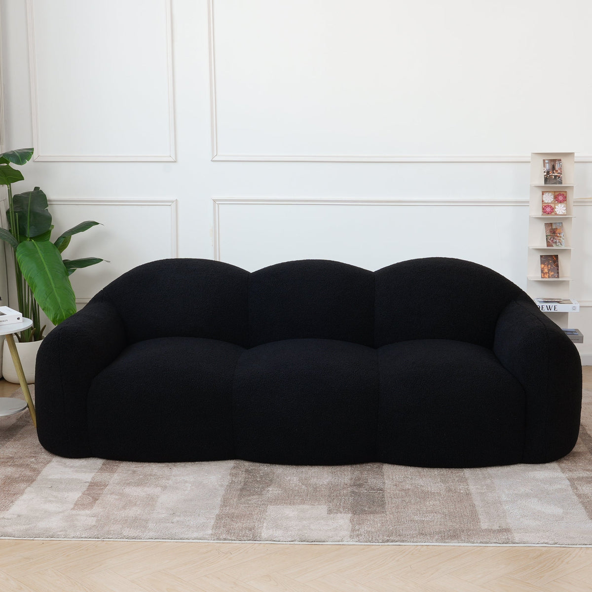 Canapé nuage 3 places avec accoudoirs, tissu bouclé noir charbon, en situation dans un intérieur