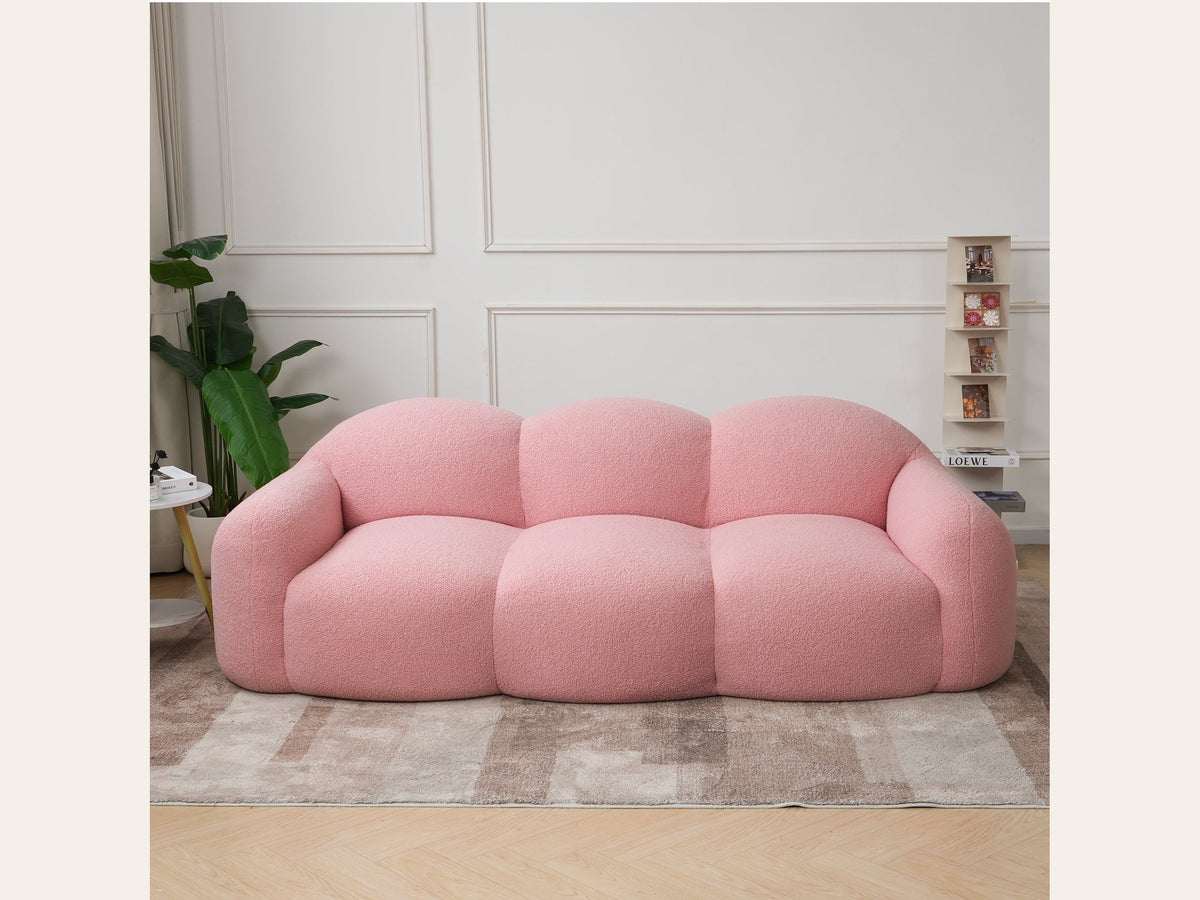 Canapé nuage 3 places avec accoudoirs, tissu bouclé rose poudré, en situation dans un intérieur