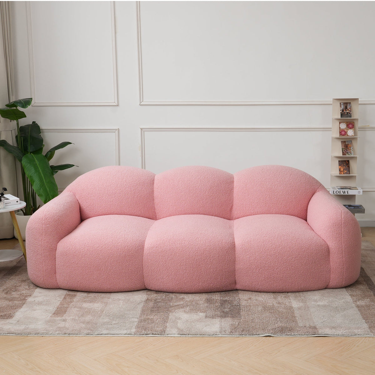 Canapé nuage 3 places avec accoudoirs, tissu bouclé rose poudré, en situation dans un intérieur