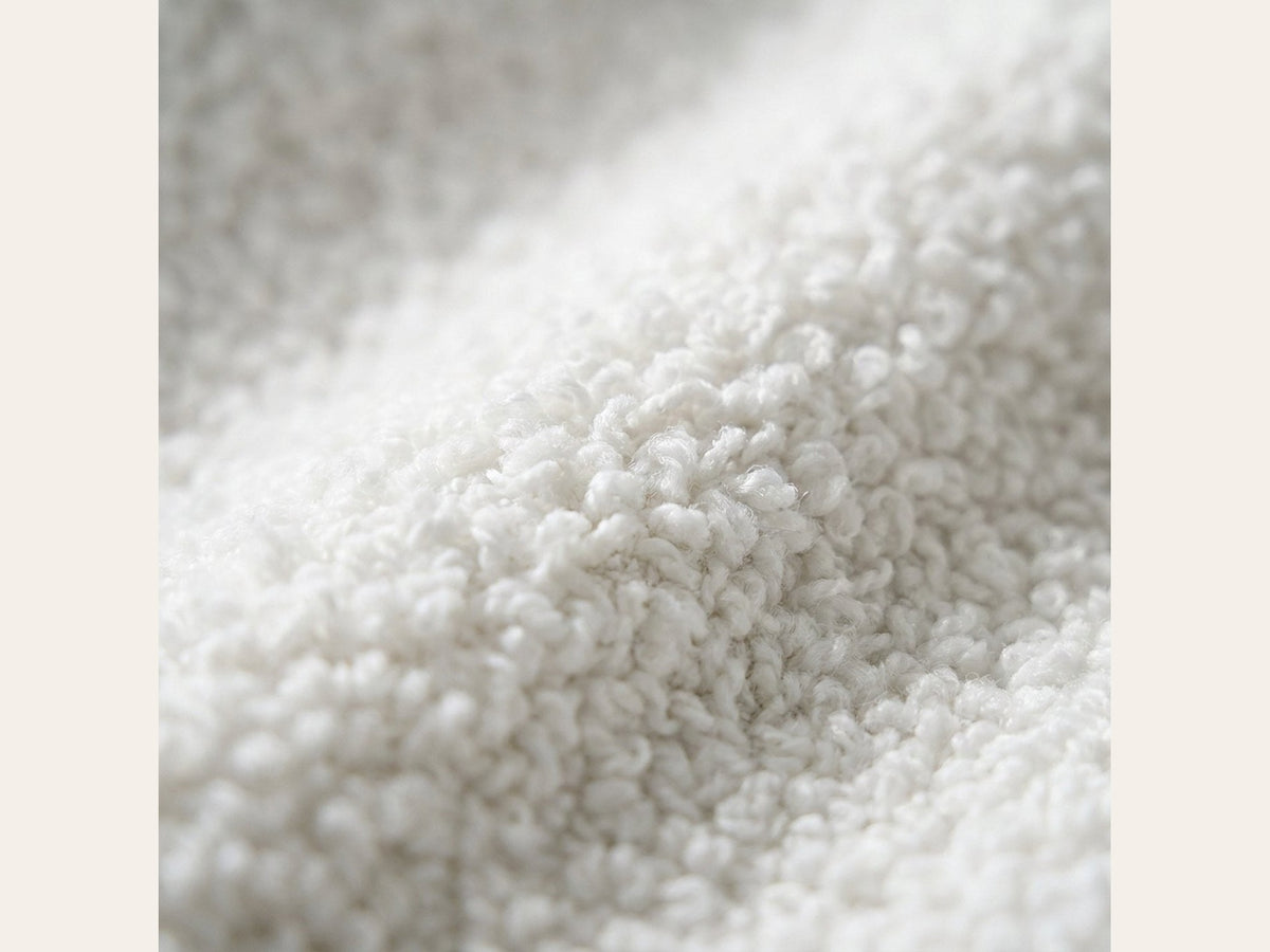 Canapé nuage 3 places sans accoudoir, gros plan sur le tissu bouclé blanc écru