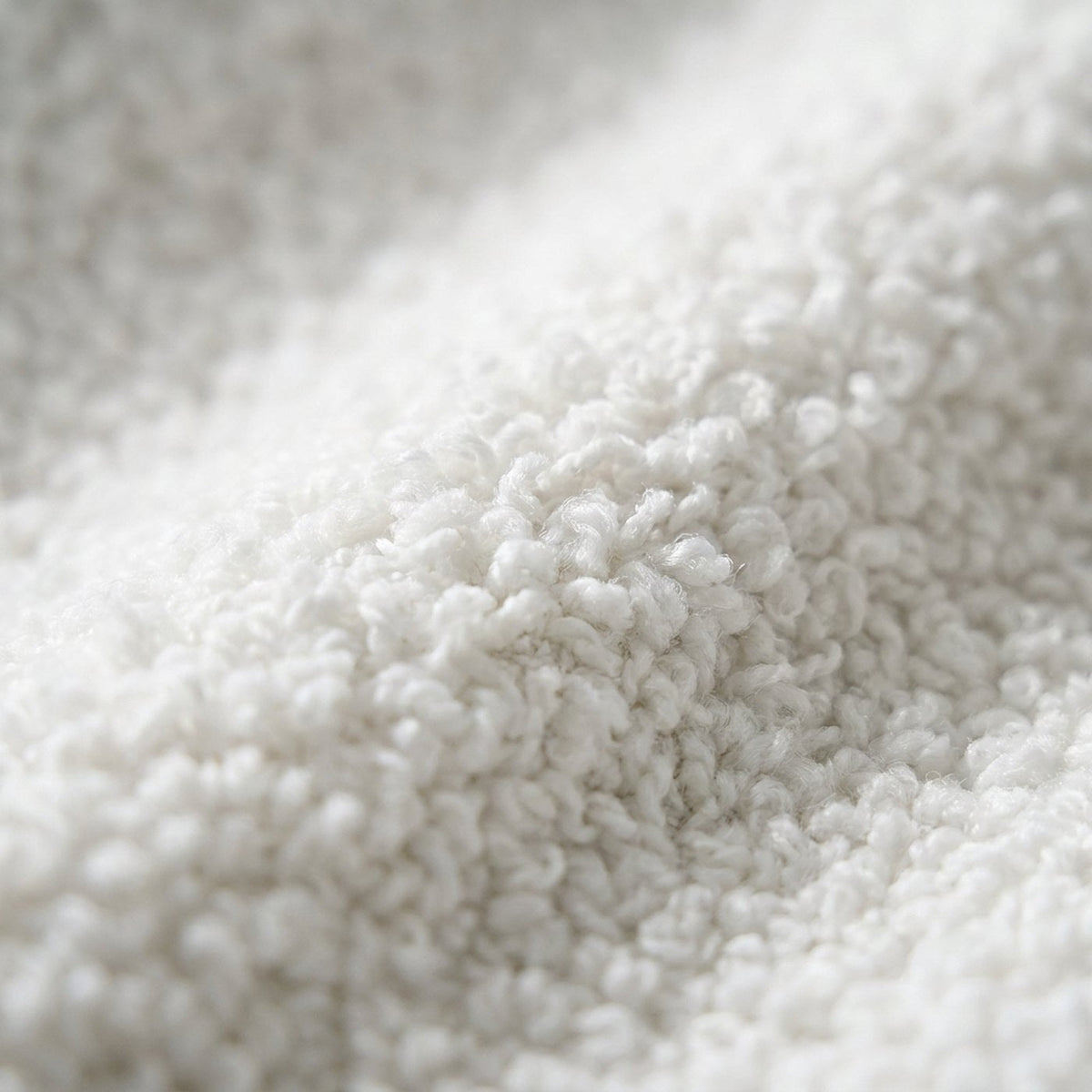 Canapé nuage 3 places sans accoudoir, gros plan sur le tissu bouclé blanc écru