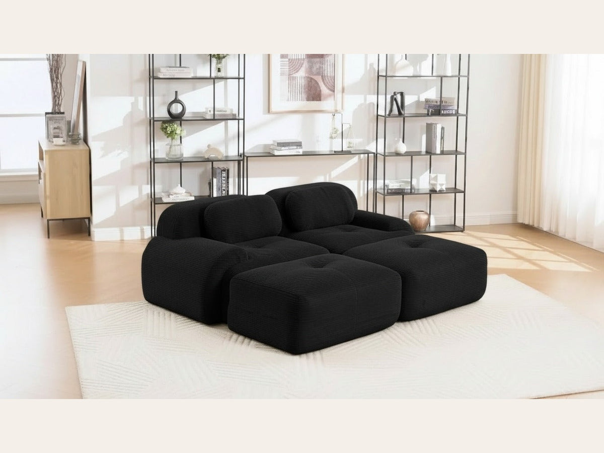 Canapé 2 places avec poufs noir, de trois quarts dans un salon