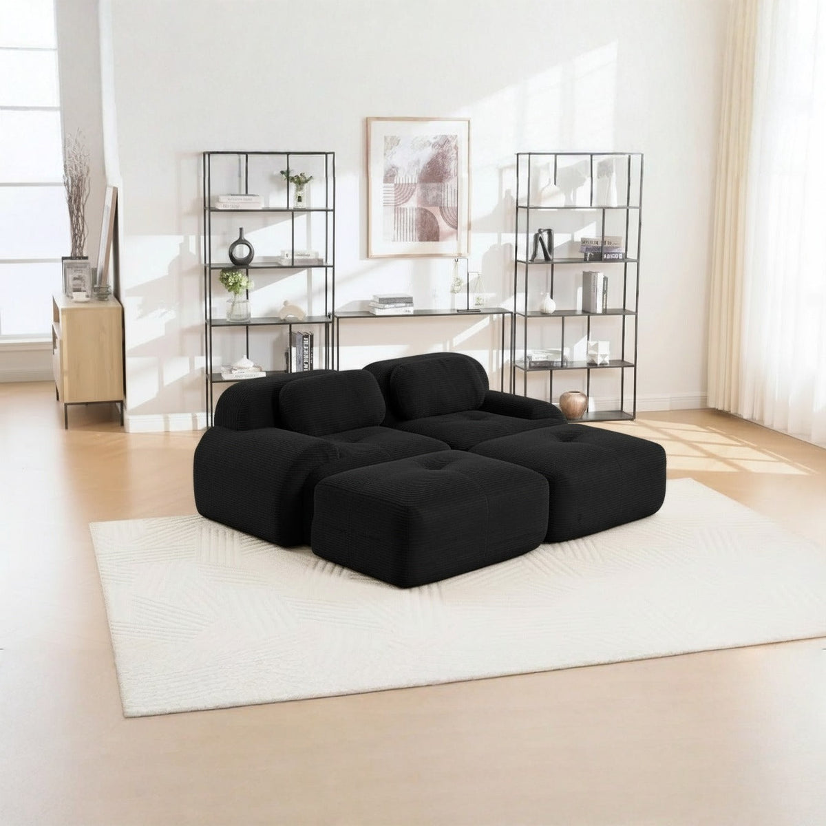 Canapé 2 places avec poufs noir, de trois quarts dans un salon