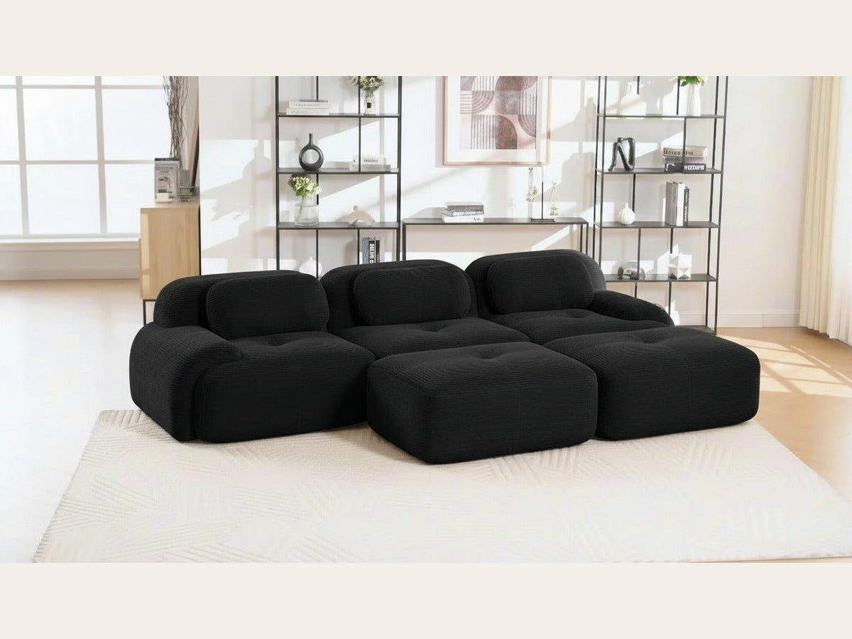 Canapé 3 places avec poufs noir, de trois quarts dans un salon
