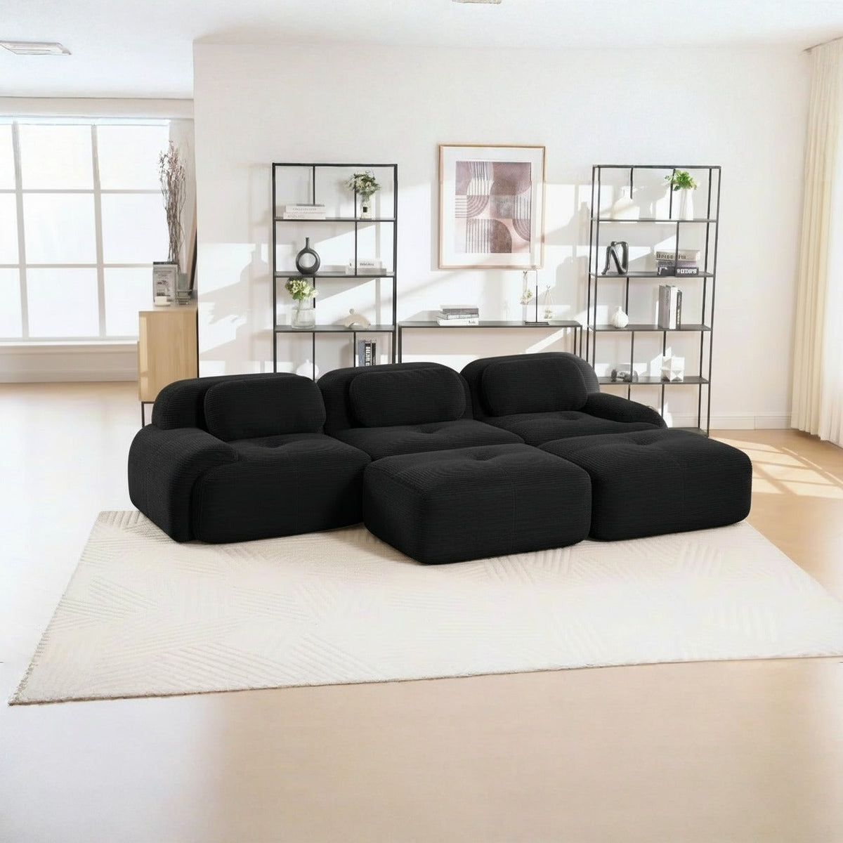 Canapé 3 places avec poufs noir, de trois quarts dans un salon