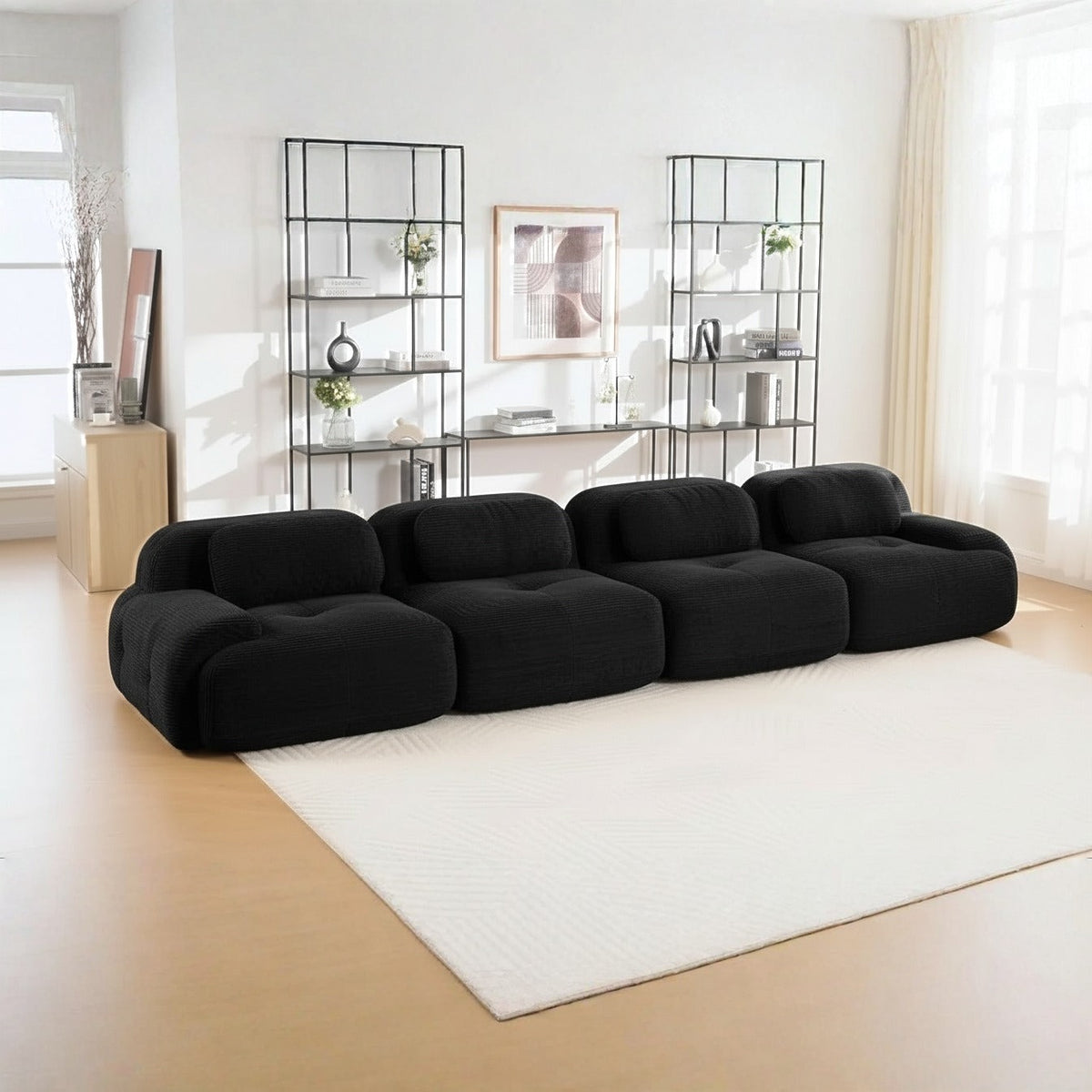 Canapé 4 places velours côtelé noir, de trois quarts dans un salon