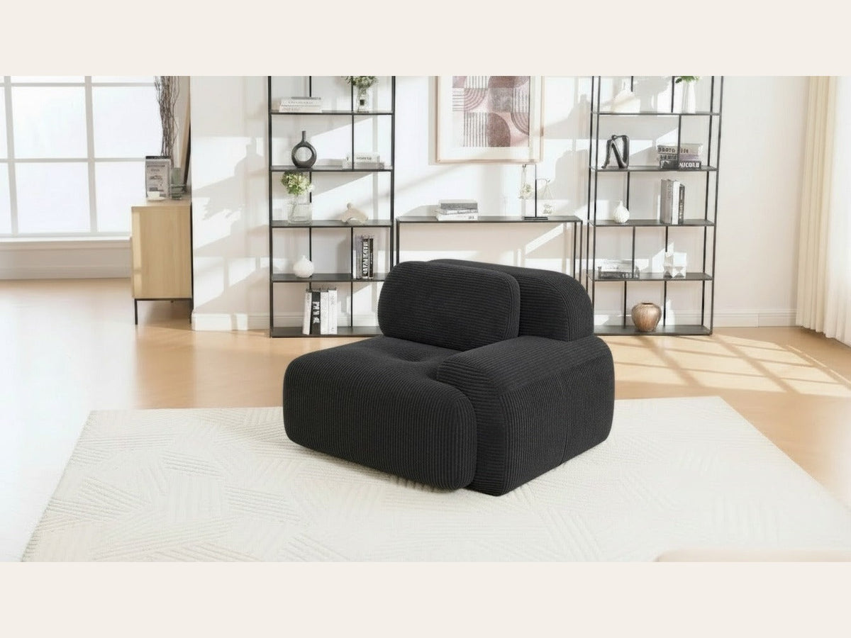 Fauteuil modulable noir, de trois quarts dans un salon