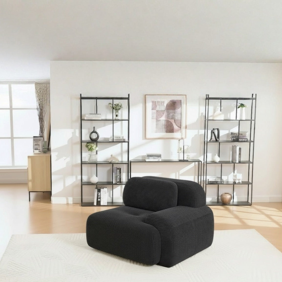 Fauteuil modulable noir, de trois quarts dans un salon