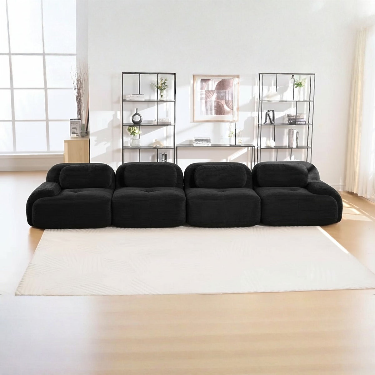 Canapé 4 places velours côtelé noir, de face dans un salon