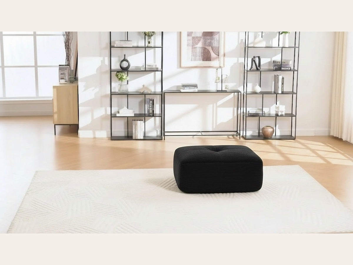 Pouf velours côtelé noir, de face dans un salon