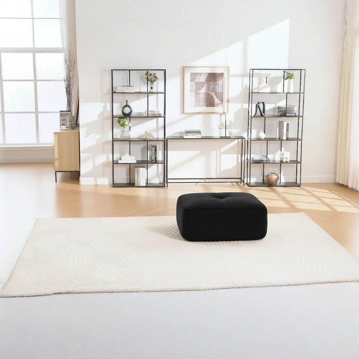 Pouf velours côtelé noir, de face dans un salon