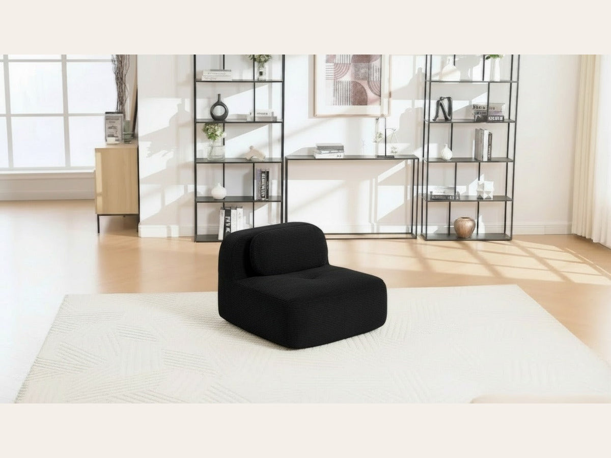 Chauffeuse velours côtelé noir, de trois quarts dans un salon