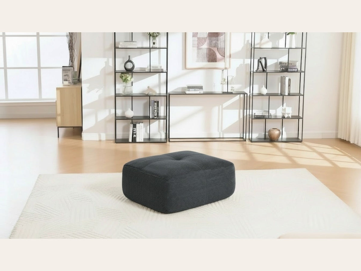 Pouf velours côtelé gris, de trois quarts dans un salon