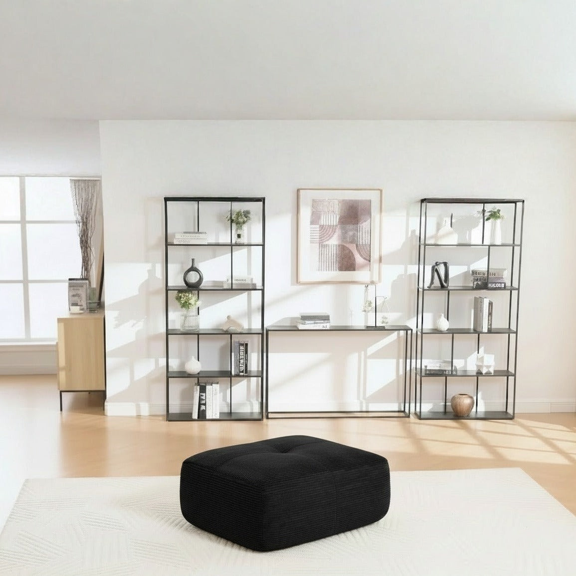Pouf velours côtelé noir, de trois quarts dans un salon