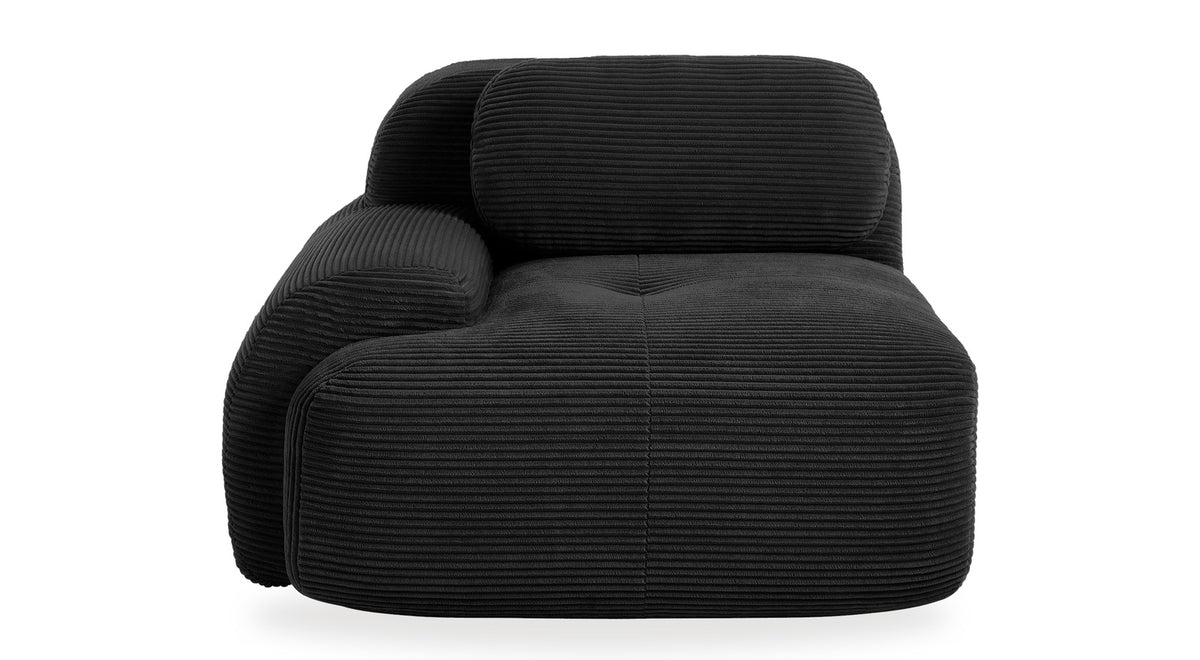 Fauteuil modulable noir, vue de trois quarts sur fond blanc, accoudoir à gauche sur l'image