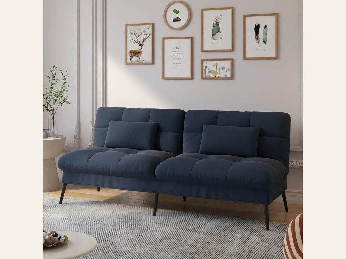 Canapé convertible en velours, coloris bleu profond, dans une pièce