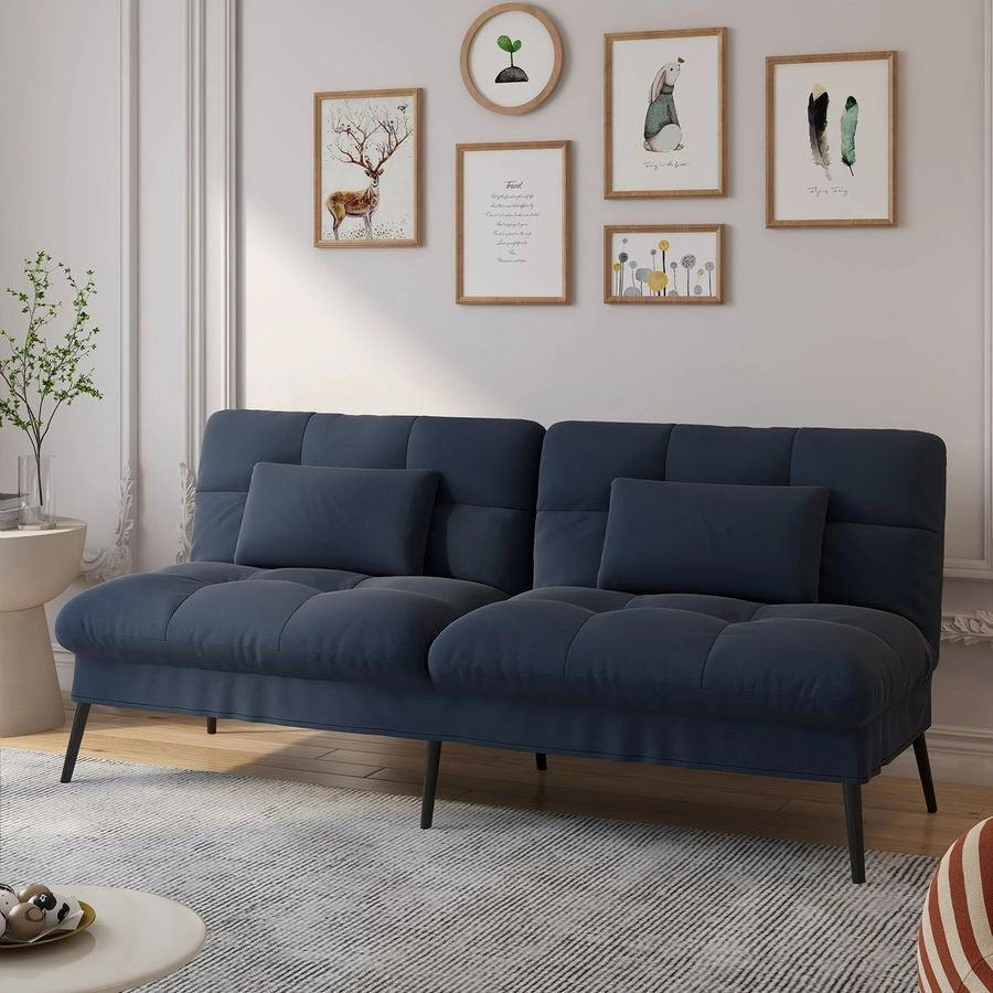 Canapé convertible en velours, coloris bleu profond, dans une pièce