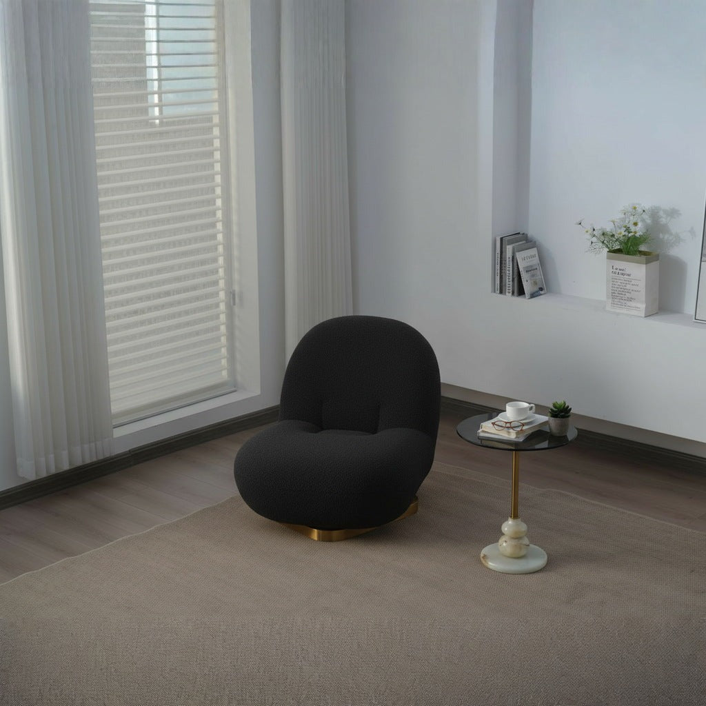 Fauteuil nuage pivotant 360 en tissu bouclette noir charbon, installé dans un angle de pièce, près d'une fenêtre