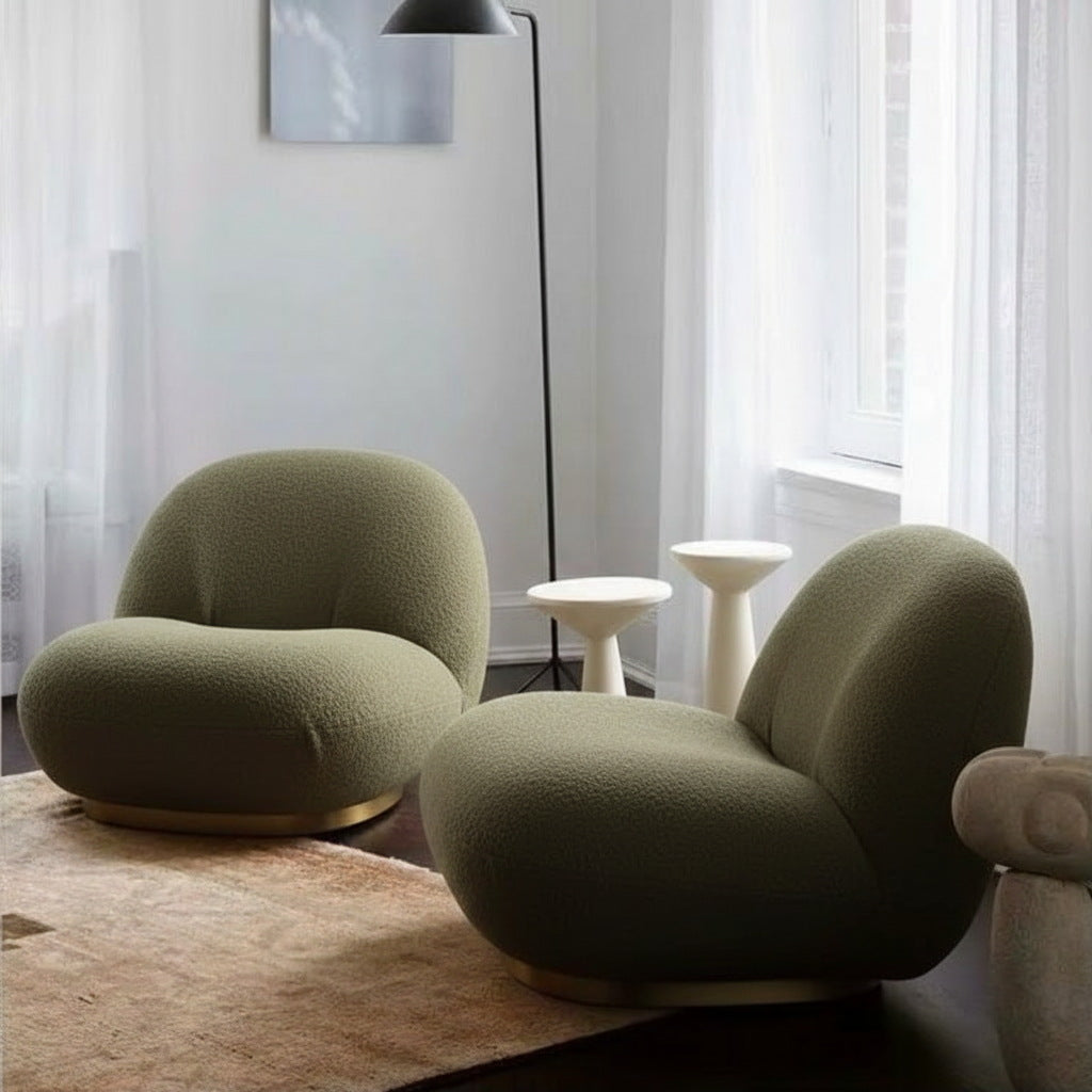 Fauteuil nuage pivotant 360 en tissu bouclette vert kaki, présenté en duo dans un salon, avec lampadaire et tables d'appoint