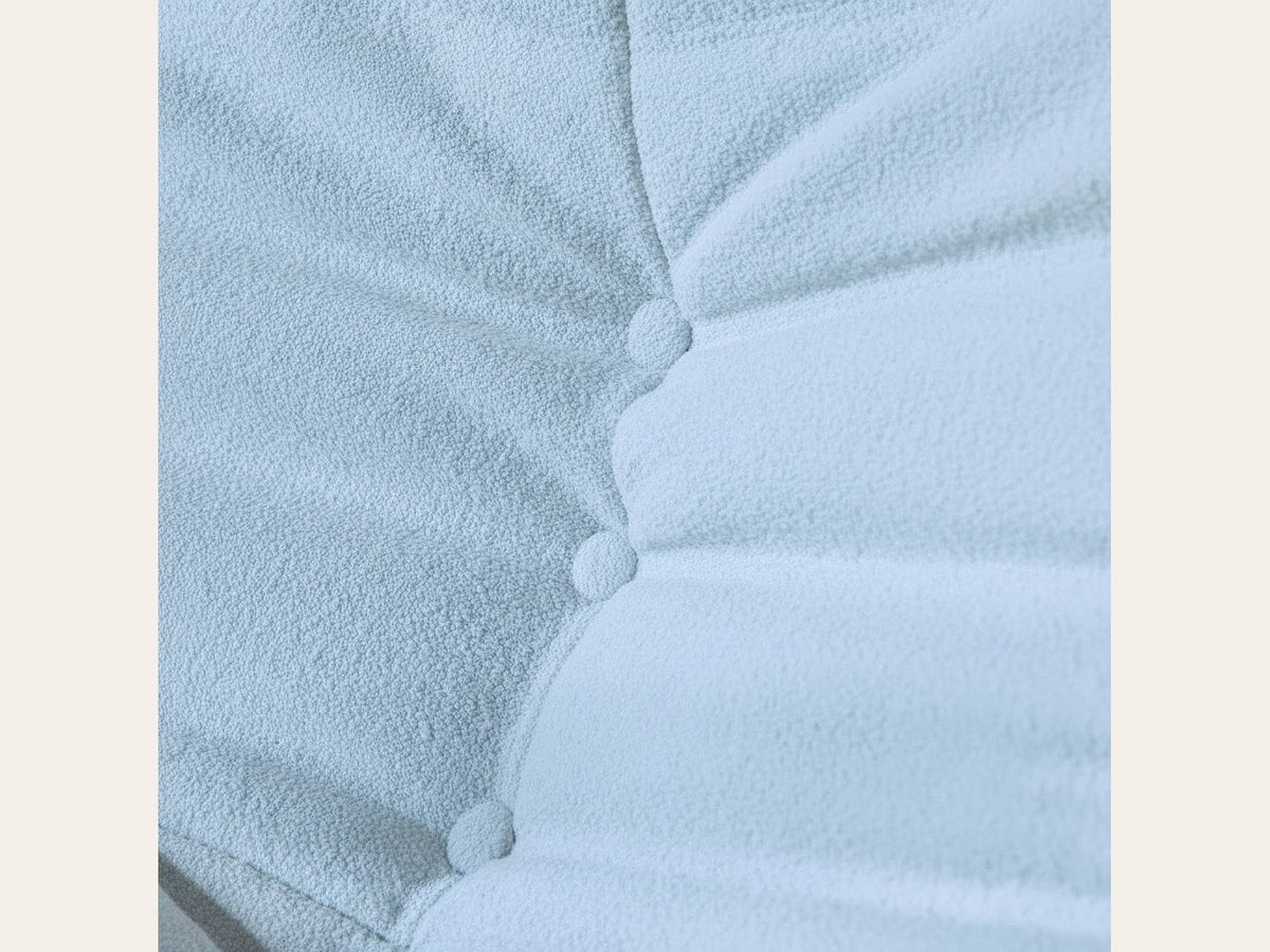 Pouf repose-pieds bas, gros plan sur le velours teddy bleu ciel