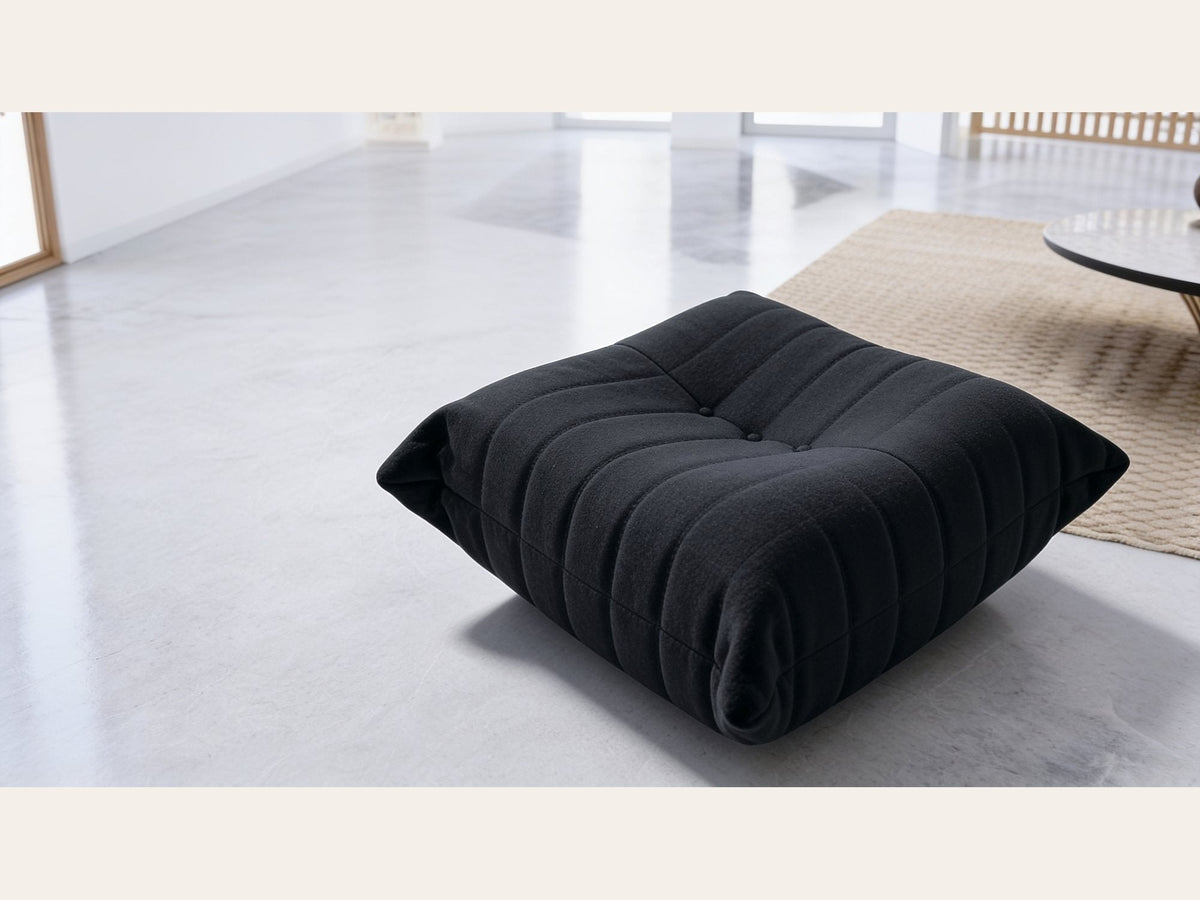 Pouf repose-pieds bas, velours teddy noir charbon, en situation dans un intérieur