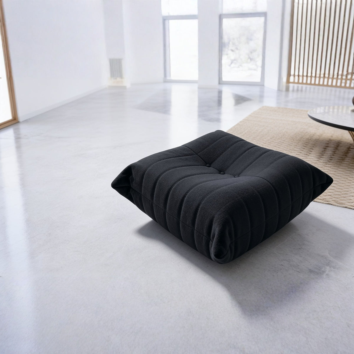 Pouf repose-pieds bas, velours teddy noir charbon, en situation dans un intérieur
