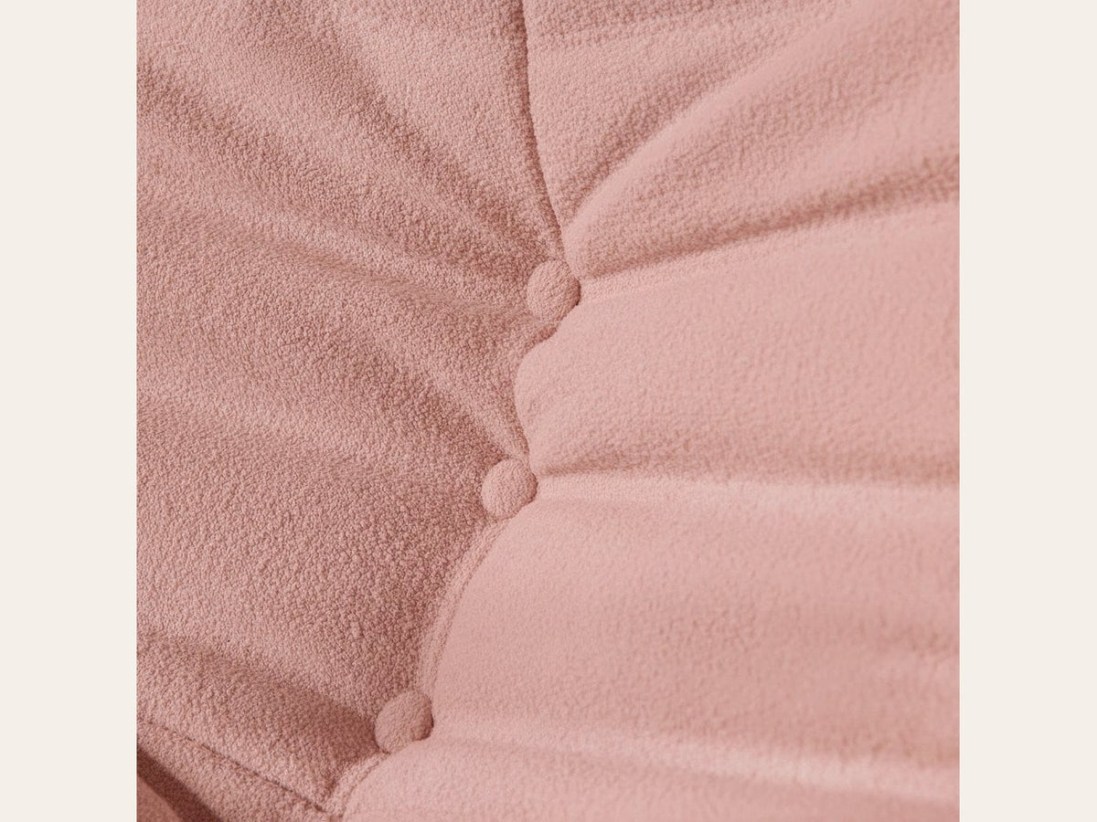 Pouf repose-pieds bas, gros plan sur le velours teddy rose poudré
