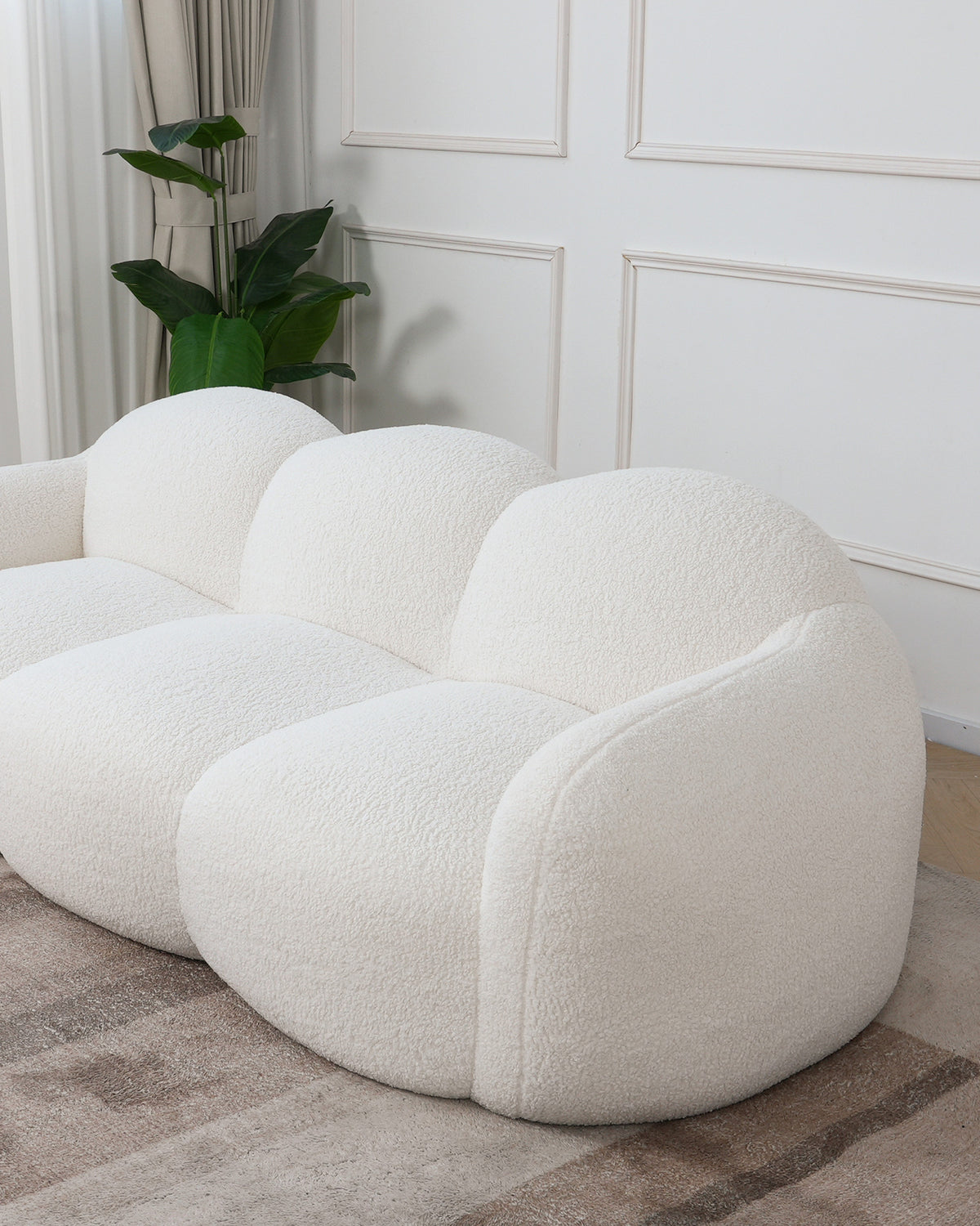 Canapé nuage en tissu bouclé blanc écru, installé dans un salon